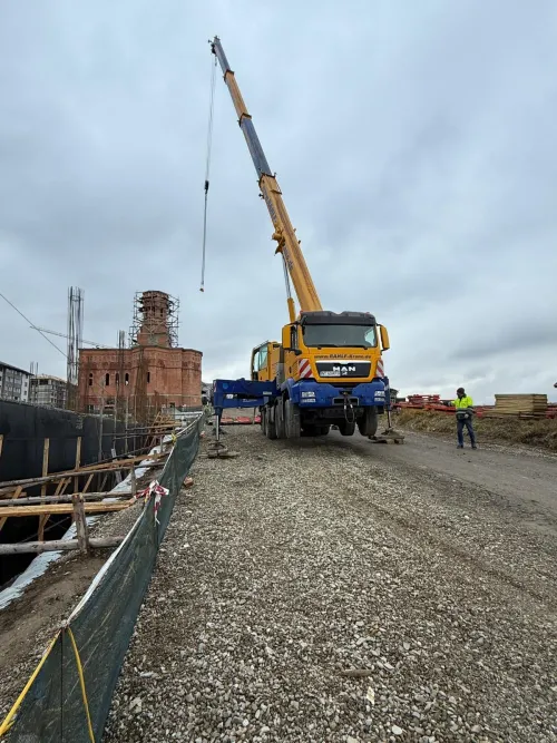 Automacara la un șantier de renovare, lângă o clădire istorică din cărămidă.