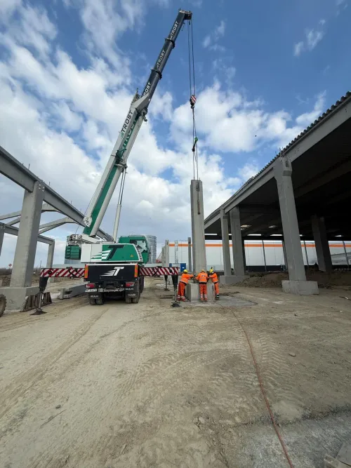 Macara mobilă lucrând sub structura unui viaduct în construcție.