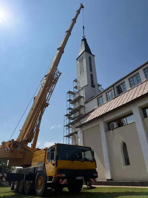 Automacara poziționată lângă turnul unei biserici pentru lucrări la înălțime.