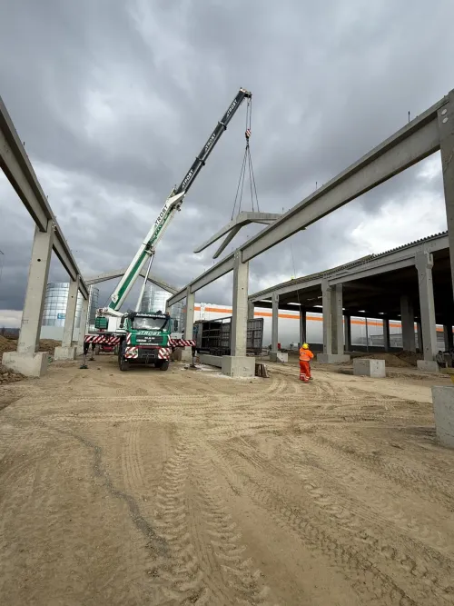 Automacara și camion pe un șantier de viaduct, într-o zi cu ceață.