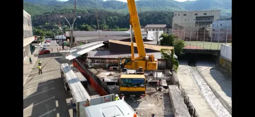 Automacara lucrând la traversarea unui canal urban, vedere de ansamblu asupra orașului.