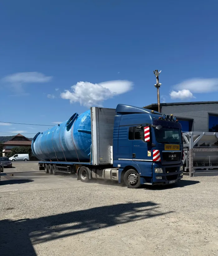 Cap tractor MAN cu însemnul "Transport exceptional", transportând un rezervor cilindric supradimensionat pe platformă.